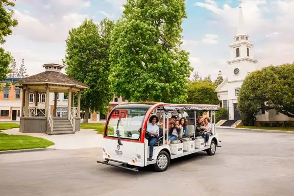 Guests riding a tour cart through the Warner Bros. Studio Tour Hollywood backlot