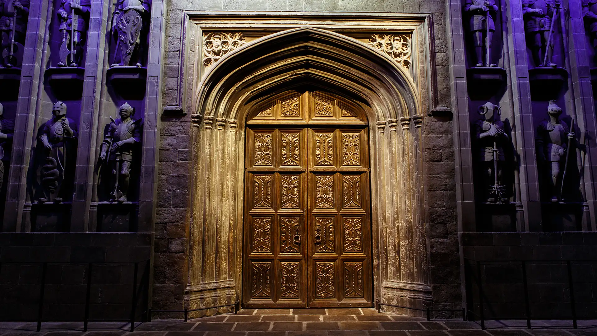 Ornate golden doors of Hogwarts Great Hall with armored statues